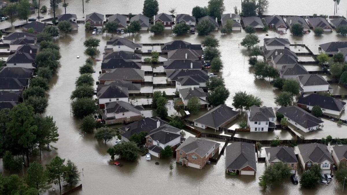 In this Tuesday, Aug. 29, 2017, file photo, homes are surrounded by floodwaters from Tropical Storm Harvey in Spring, Texas. The House has passed legislation that will increase flood insurance premiums for many property owners to help firm up a program under stress from ever-more frequent and powerful storms.