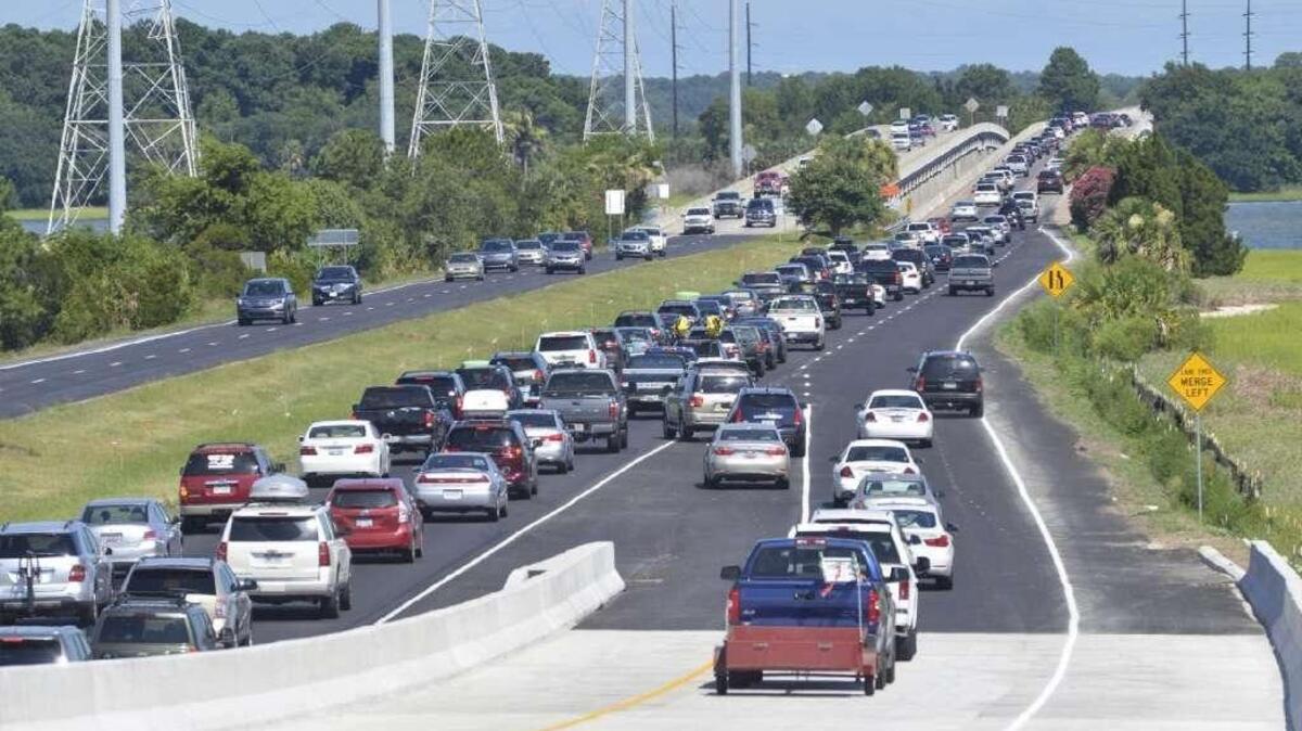 Vehicles headed to Hilton Head Island merge on thick traffic U.S. 278 at the bottom of the Bluffton Parkway flyover ramp at about 4 p.m. on Saturday, July 16, a busy day for tourist arrivals and the new flyover’s first full day of operation.