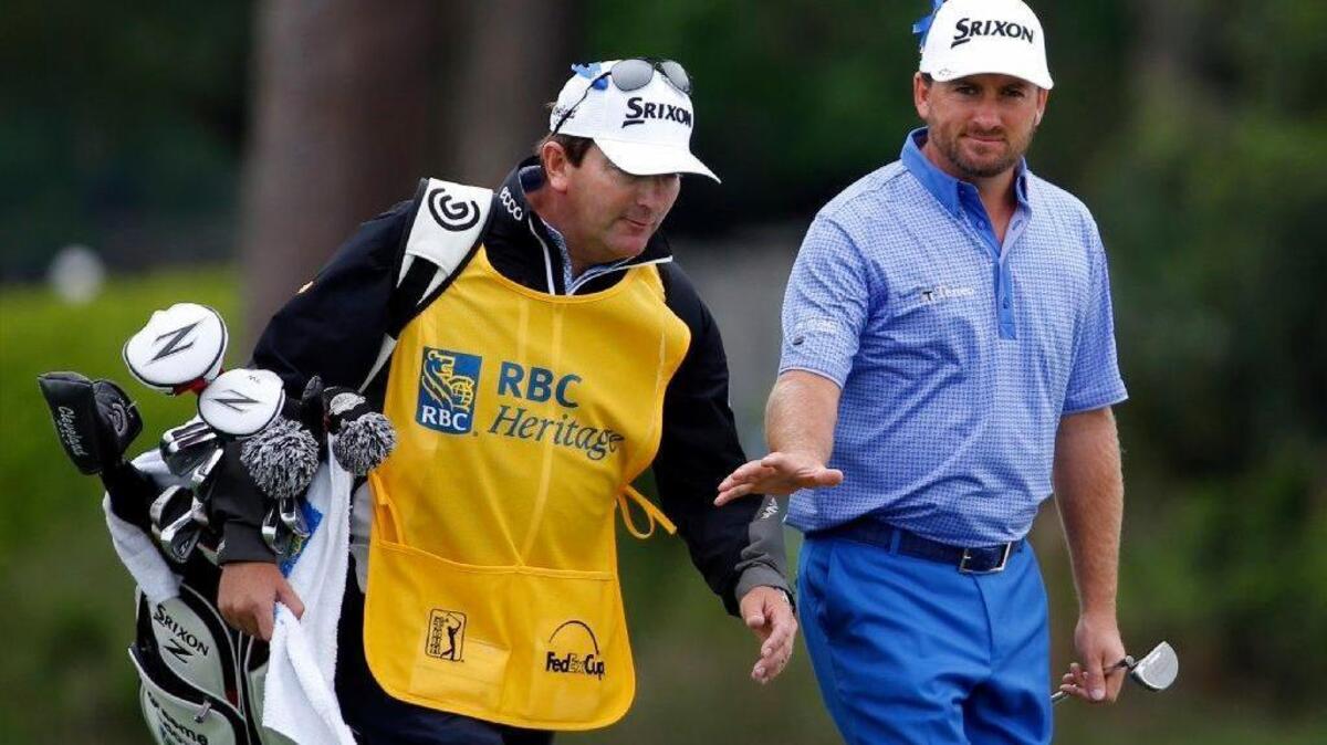 Past champion and Team RBC member Graeme McDowell, of Northern Ireland, talks to his caddie as he walks onto the 17th green during the RBC Heritage Presented by Boeing.