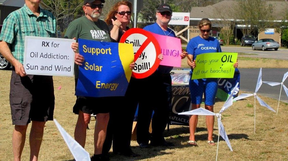 Opponents of opening waters off the Carolinas coast to exploration for oil and natural gas hold signs on Wednesday, March 11, 2015 in Mount Pleasant, S.C. They were standing outside a motel where the federal Bureau of Ocean Energy Management held a meeting to take public comment on opening areas to drilling. The agency was to use the comments in deciding what should be included in environmental studies of the proposal.