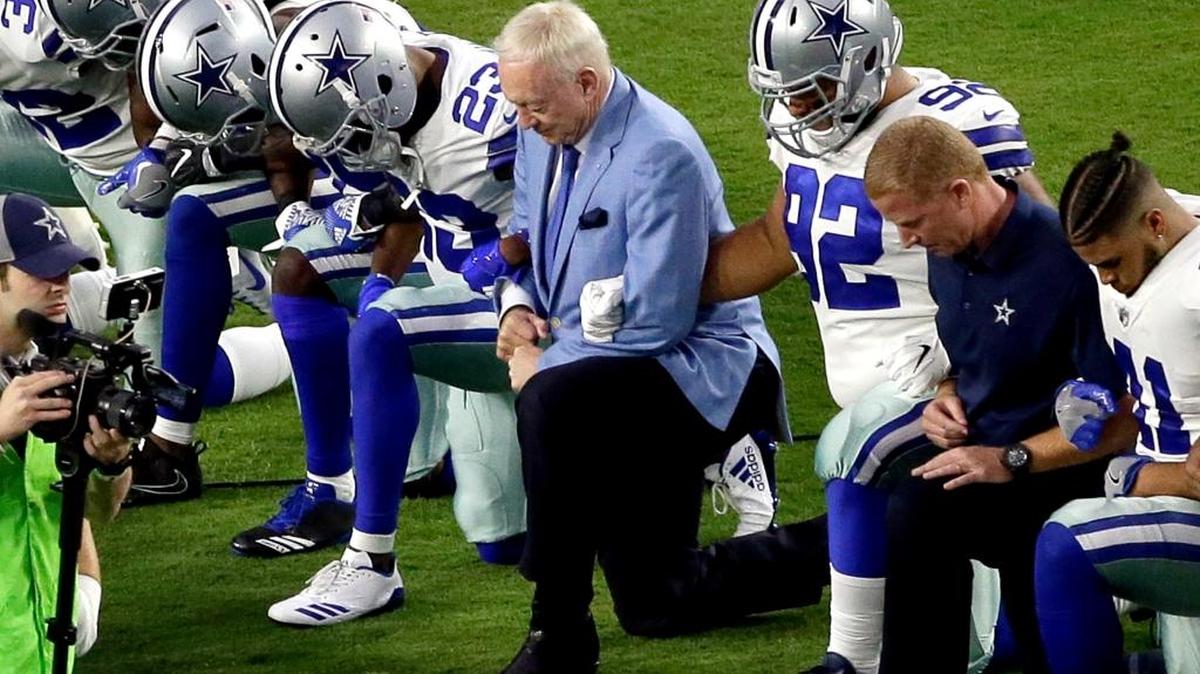 The Dallas Cowboys, led by owner Jerry Jones, center, take a knee prior to the national anthem prior to an NFL football game against the Arizona Cardinals, in Glendale, Ariz., on Monday, Sept. 25, 2017.