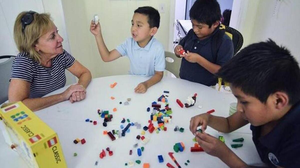Volunteer Lauri Mitchell supervises on Sept. 7, 2016, as some of the younger students play with Lego blocks during an after-school session at the Cordillo Courts branch of the Neighborhood Outreach Connection.