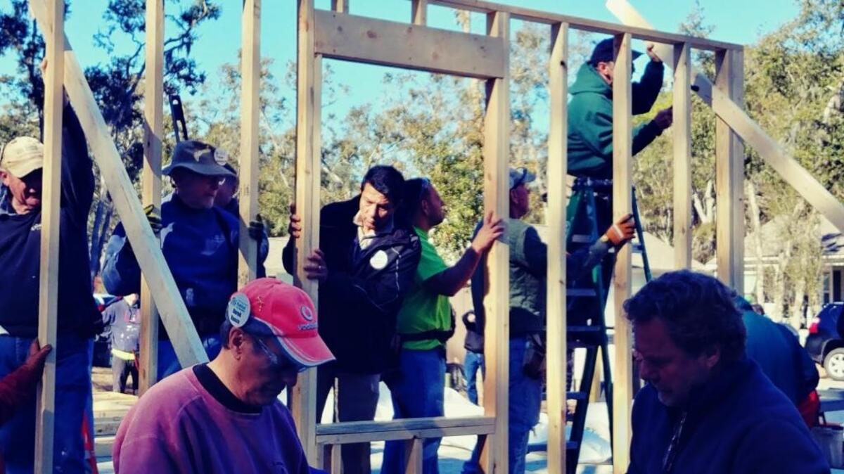 Pedro Bermudez, center, helps raise the walls for his future home in The Glen neighborhood on Hilton Head Island, South Carolina. It is the 11th home sponsored by residents of the Colleton River Club in Bluffton, where he works.