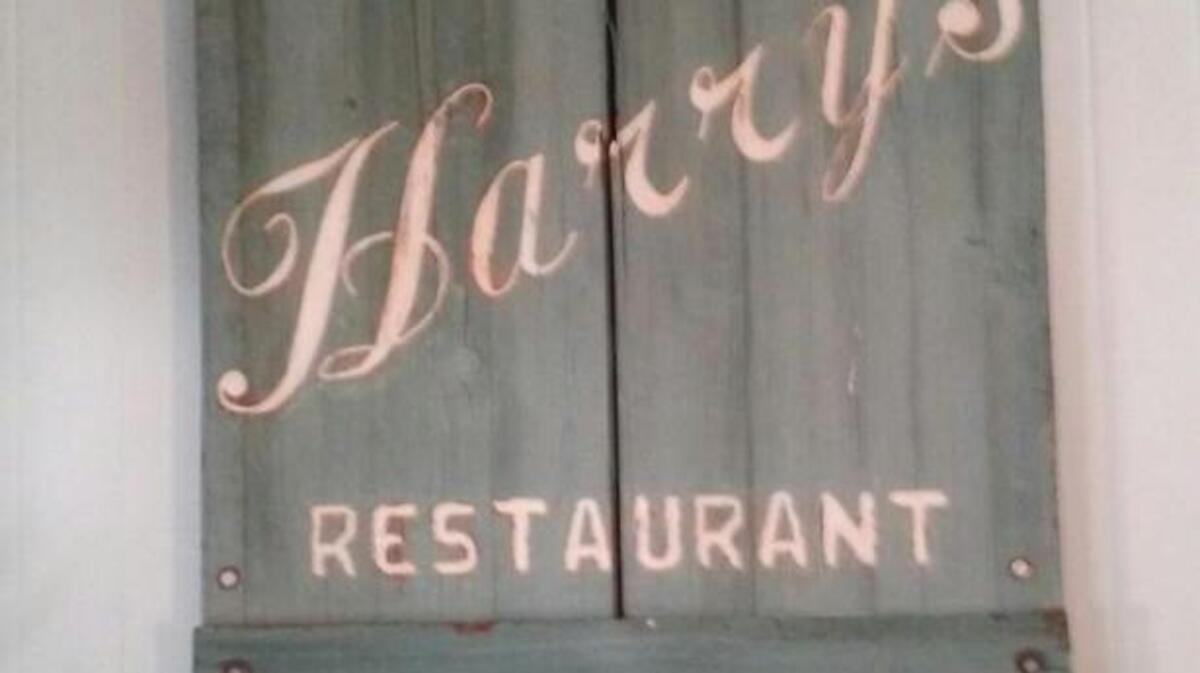 The sign from Harry’s Restaurant on the bedroom wall of Jim Torcom in Beaufort.
