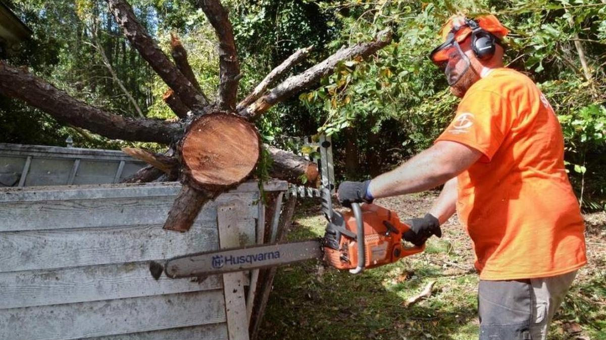 Samaritan’s Purse volunteer Ryan Bishop, of Okatie, saws away at a tree that fell in the yard of Heritage Lakes resident Dean Sutton as the cleanup for Hurricane Matthew continued on Oct. 12, 2016.