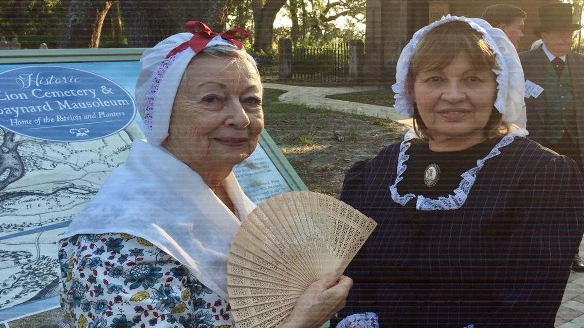 Peggy Pickett, left, dressed as Lydia Davant, believed to the be the first person buried at the Zion Chapel of Ease Cemetery on Hilton Head Island, and Dee Phillips dressed as Mary E. Baldwin Kirk, also buried there, pose in the cemetery Thursday, Sept. 21, 2017, at a ceremony to announce a $135,000 gift from The Church Mouse thrift shop to restore the Baynard Mausoleum, seen in the background