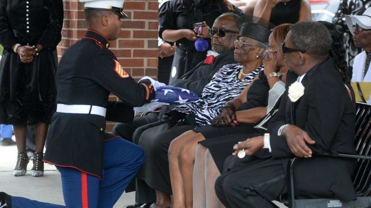 A Marine hands the folded American flag to Lucinda Washington, wife of the late Rev. Frankie Washington, during his funeral at the Beaufort National Cemetery on Friday in Beaufort.