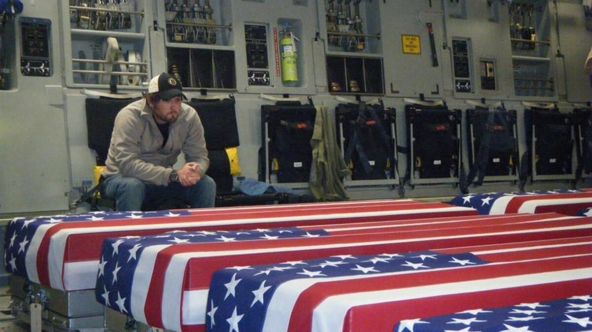 Chris Cullen on the flight to Dover Air Force Base from Afghanistan on March 13, 2013, watching over the remains of his wife, U.S. Army Capt. Sara Knutson Cullen, and four others killed March 11, 2013, in a Black Hawk helicopter in Kandahar.