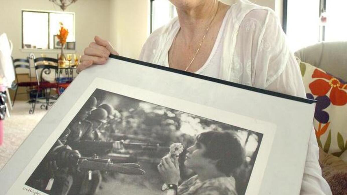 In this file photo from April 2007 shows Jan Rose Kasmir holding her copy of the Marc Riboud photograph taken in 1967 outside the Pentagon during a demonstration protesting the U.S. war in Vietnam.