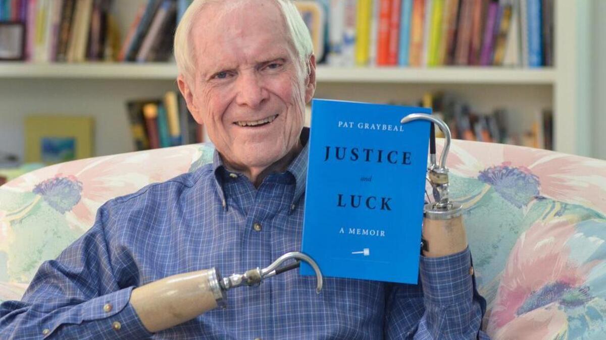 Hilton Head Islander Pat Graybeal holds a copy of his memoir, “Justice and Luck.” He says that, despite having lost his hands in a 1973 bombing, he still feels very fortunate: “I feel like I’m one of the luckiest people who ever lived.”