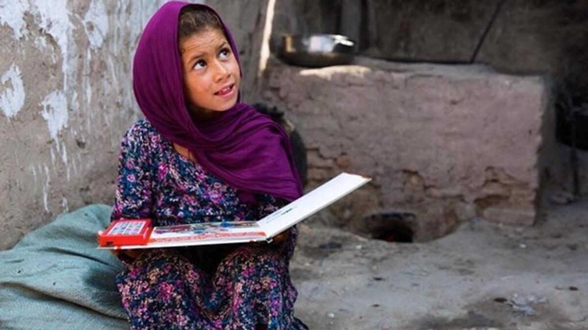 A child in Pakistan reads a “speaking book” produced by Brian Julius of Hilton Head Island as part of a worldwide effort to eradicate polio.
