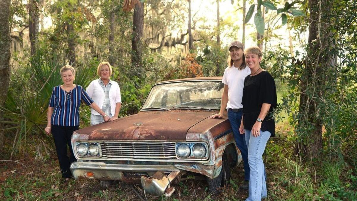 From left, Agnes Pinckney, Kate Pinckney, Robert Pinckney and Karen Floyd stand next to their family’s old car that sat next to the Pinckney Colony Road on their property in Bluffton for more than 20 years. They were recently contacted by the county and asked to move it so that it wasn’t visible from the road.