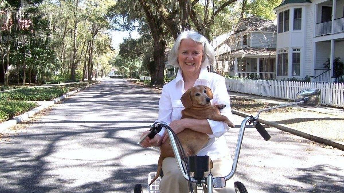 Anne Guthrie poses on a three-wheeled bicycle with her first little red dog, Stephanie, in her Newpoint neighborhood on Lady’s Island.