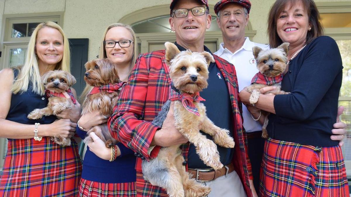 Holding their Yorkies in front of their house on the 12th hole of Harbour Town Golf Links, the Vairo family, from left, Felicia, Emily and Peter pose on Friday with family friends David and Barbara Eppinger in Heritage tartan attire acquired at thrift shops by Felicia.
