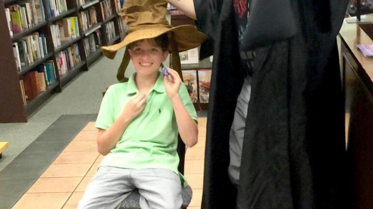 Cass Balken, store manager of the Barnes and Noble on Hilton Head Island, puts the Sorting Hat on Rocket Rosenberry of Hilton Head at the midnight release party for “Harry Potter and the Cursed Child.”