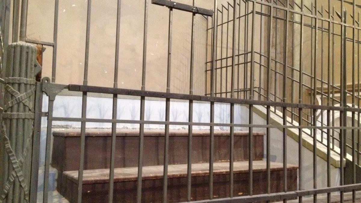 A stock image of an empty holding cell in a courtroom.
