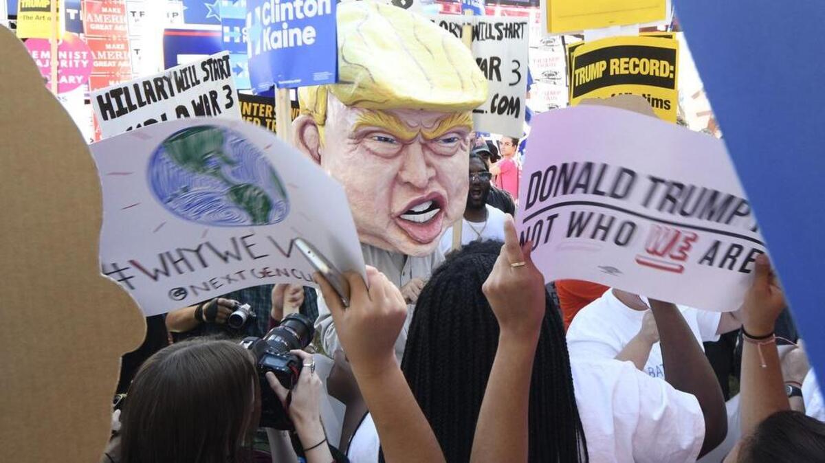 Tom Moran, center, wears a large Trump head in the middle of a rally hours before the debate on Oct. 19 in Las Vegas, Nevada.