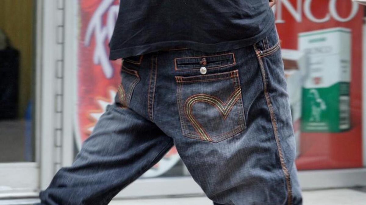 A man wears pants well below the waist as he walks on a street in Nashville, Tenn.
