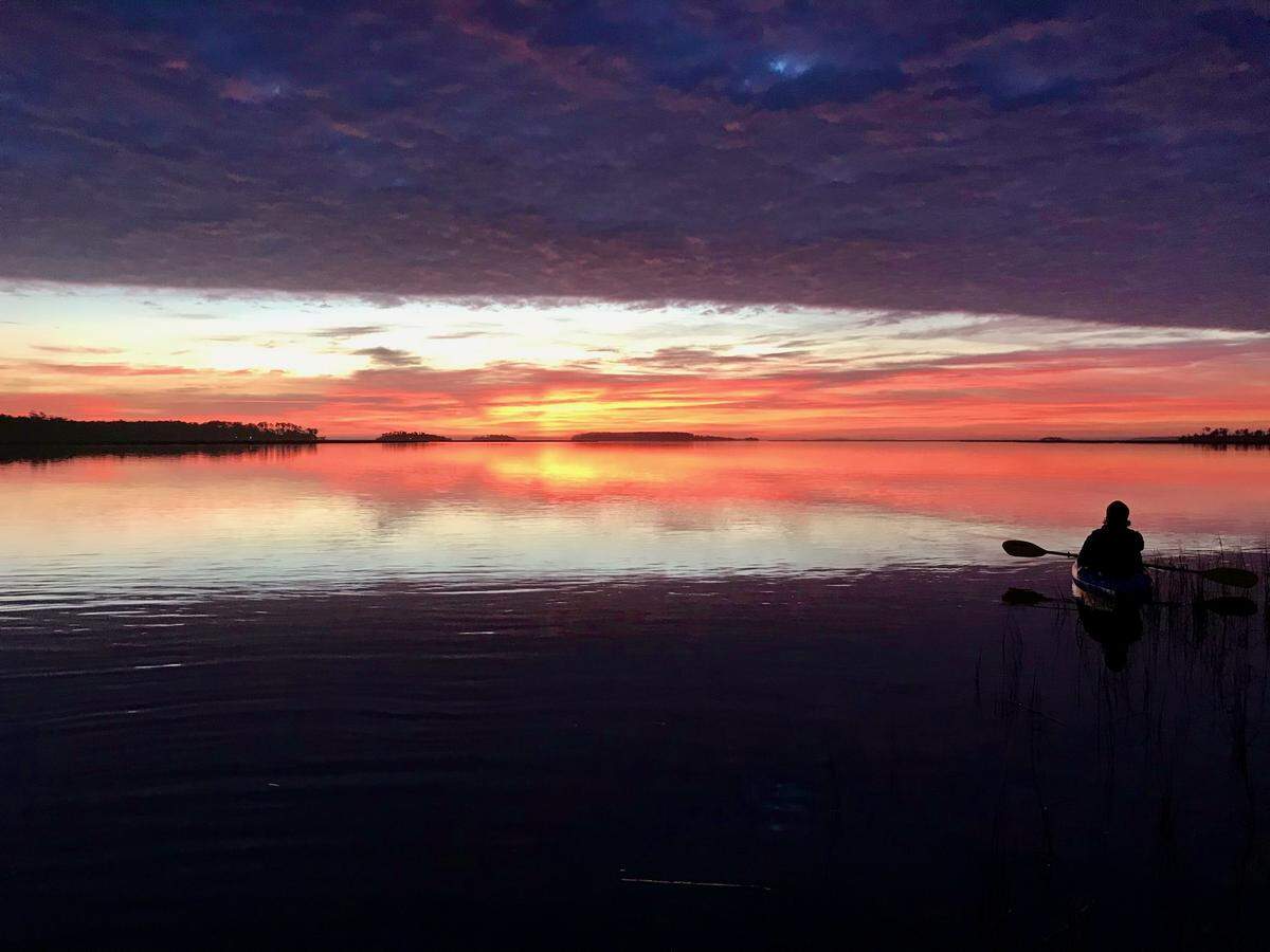 A new day on the old river: Dawn breaks over the Chechessee River, one of the many waterways that comprise Port Royal Sound. Here, kayaker James Brown of Bluffton enjoys the view. This beautiful river is a magnet for boating, fishing and outdoor recreation. A dawn paddle will place you and your kayak in a front-row seat for a spectacular sunrise.