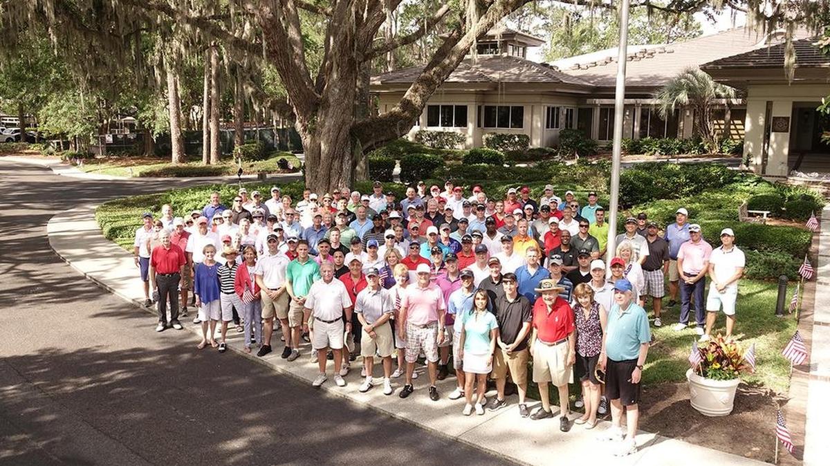 The Sea Pines Country Club members and service men and women pose outside the Sea Pines Country Club before the Tee It Up for the Troops golf tournament began.