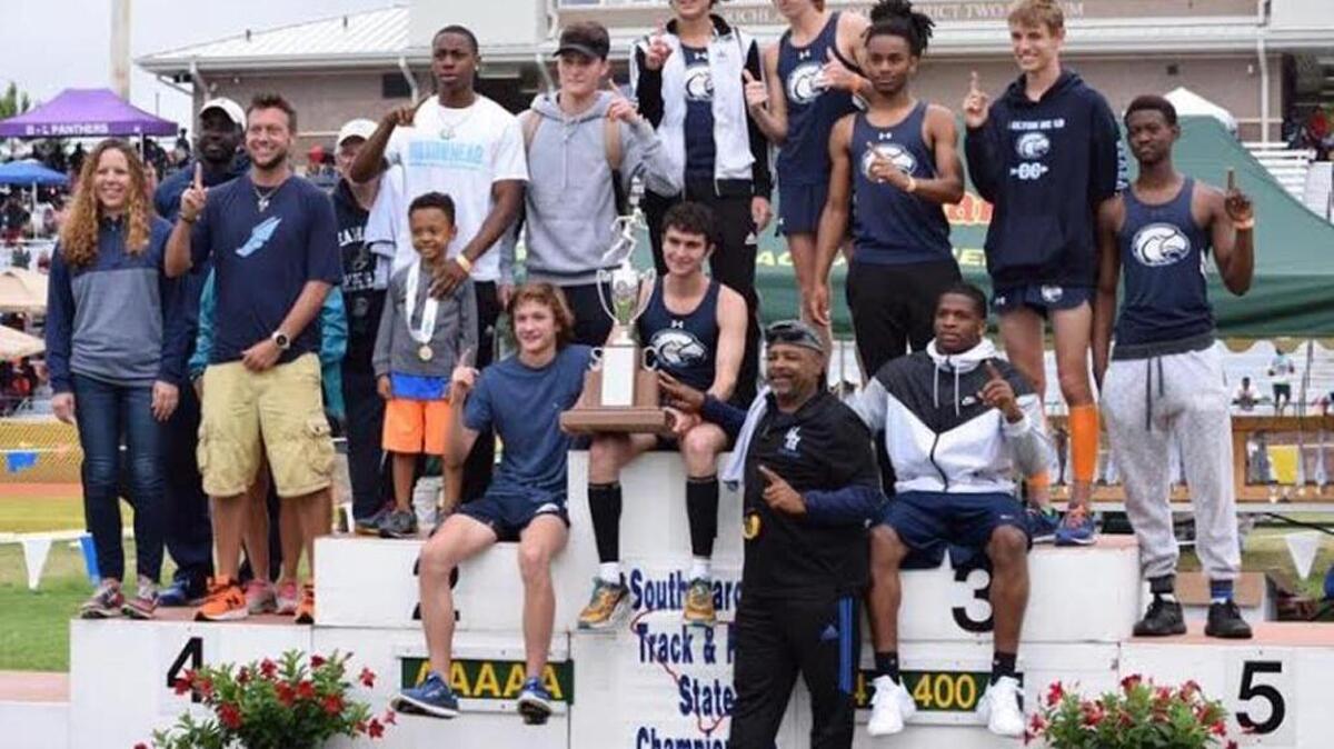 Hilton Head Island’s boys team celebrates its Class 4A title on the awards stand on May 13, 2017, in Columbia.