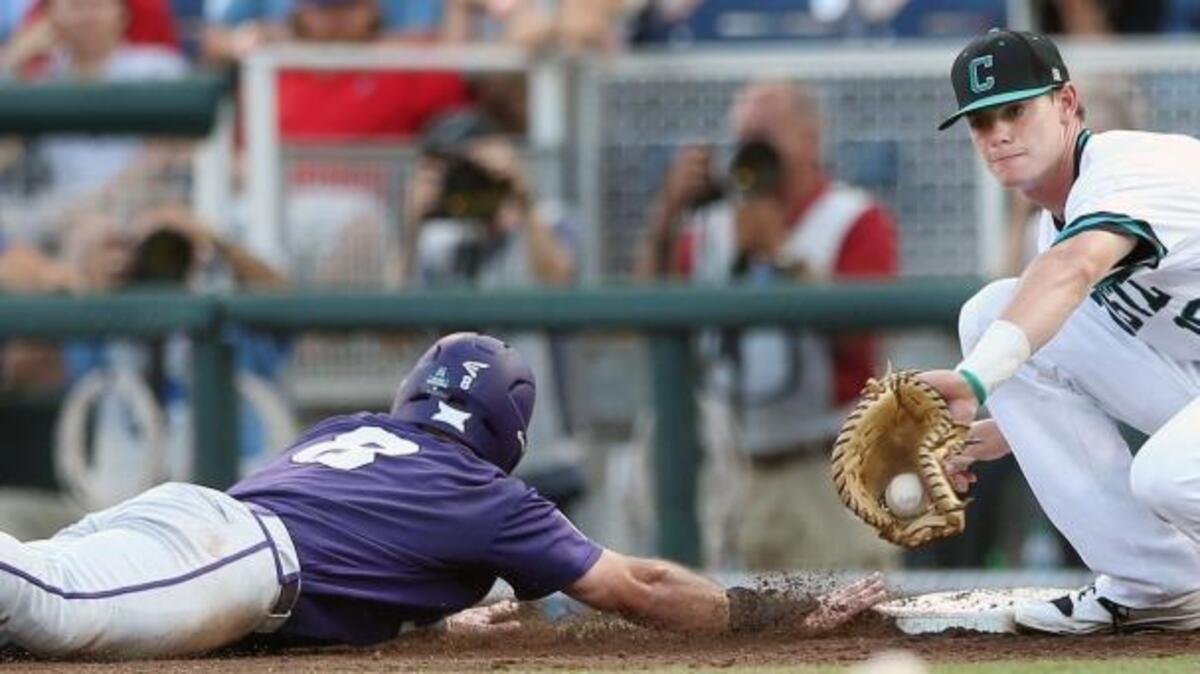 Coastal Carolina first baseman Kevin Woodall Jr. (right) handles a throw as TCU’s Austen Wade slides safely back to the base.