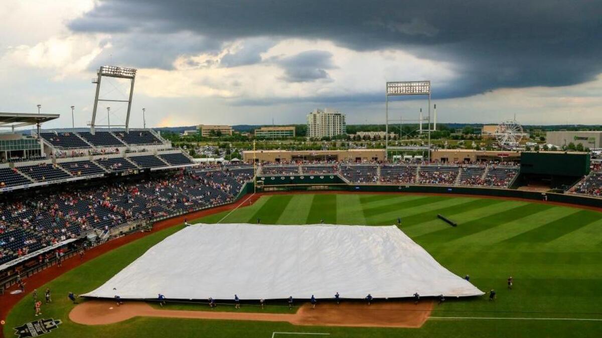 Grounds crew members pull the tarp over the playing field at TD Ameritrade Park during a weather delay before Game 3 of the NCAA College World Series finals between Coastal Carolina and Arizona in Omaha, Neb., Wednesday, June 29, 2016.