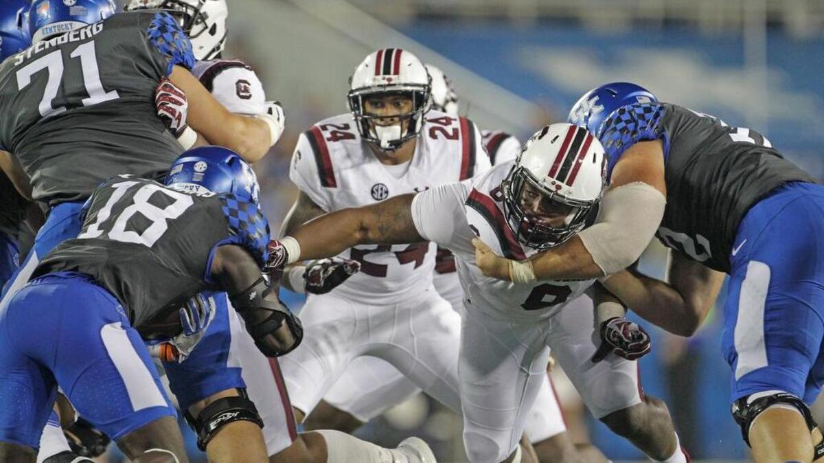 South Carolina Gamecocks defensive lineman Marquavius Lewis (8) tries to hold on to Kentucky Wildcats running back Stanley Williams (18) at Commonwealth Stadium in Lexington.