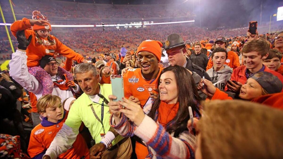 Clemson Tigers quarterback Deshaun Watson (4) takes selfies with fans as he celebrates the win over South Carolina at Memorial Stadium in November, 2016.