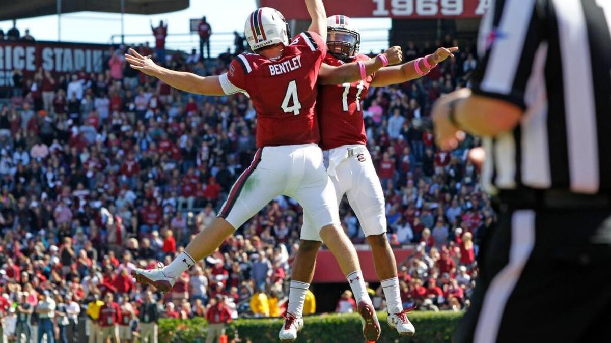 South Carolina’ Jake Bentley, left, celebrates a touchdown pass with teammate Brandon McIlwain against UMass on Saturday.