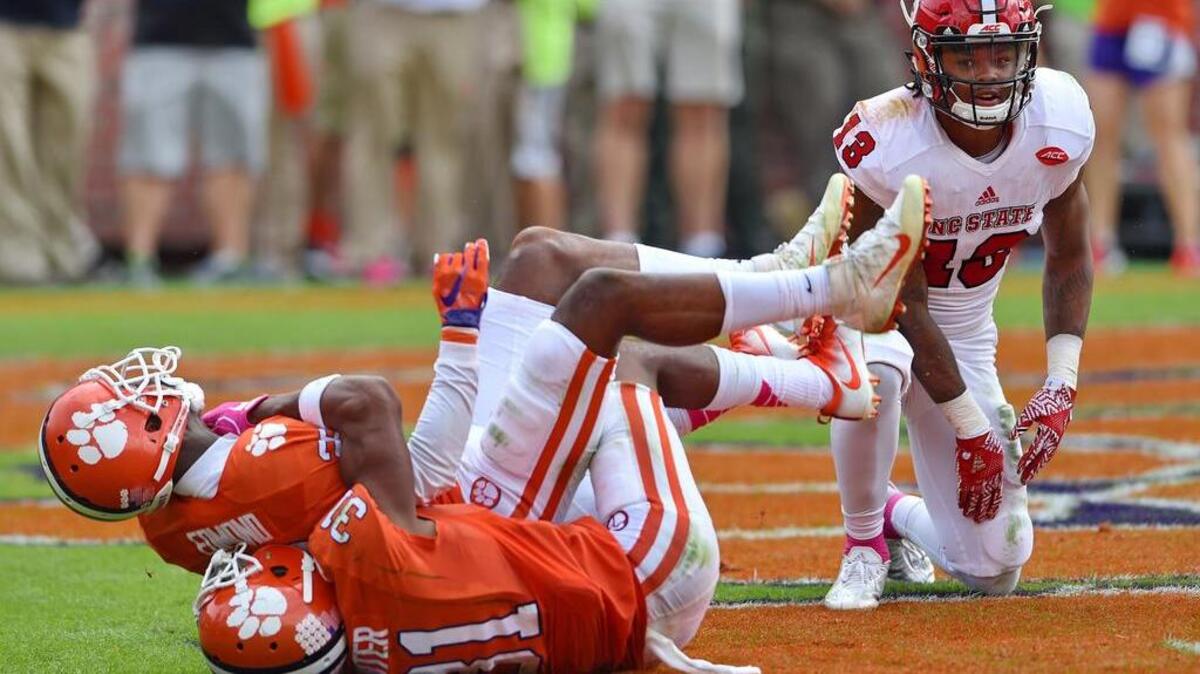 Clemson's Marcus Edmond (29) and Ryan Carter (31) celebrate Edmonds game-ending interception in overtime of an NCAA college football game while North Carolina State's Bra'Lon Cherry watches in the endzone Saturday.