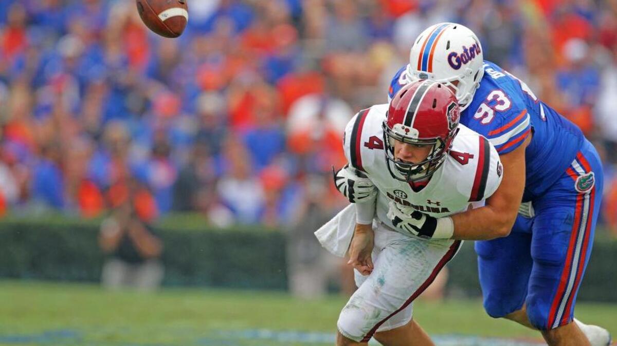 Florida defensive lineman Taven Bryan (93) causes South Carolina Gamecocks quarterback Jake Bentley (4) to fumble Saturday at Ben Hill Griffin Stadium in Gainesville, Fla.