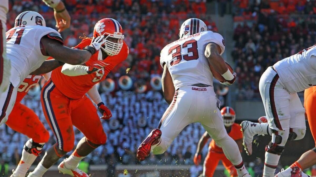 Clemson Tigers defensive end Tavaris Barnes (9) tries to stop South Carolina Gamecocks running back David Williams (33) in 2014.