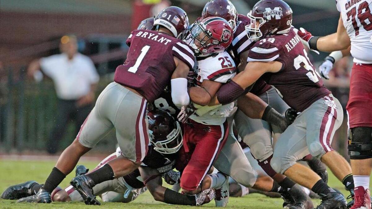 South Carolina running back A.J. Turner (25) is hit hard as he's brought down by a group of Mississippi State players at Davis Wade Stadium in Starkville, Miss.