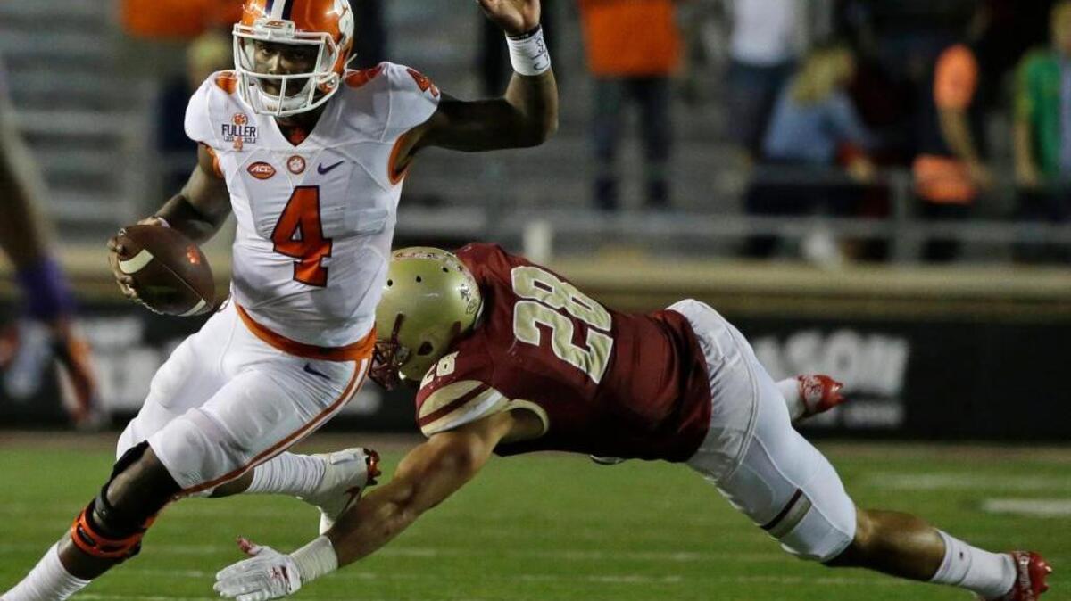 Clemson quarterback Deshaun Watson eludes Boston College linebacker Matt Milano as he scrambles with the ball during Friday night’s second half at Alumni Stadium.