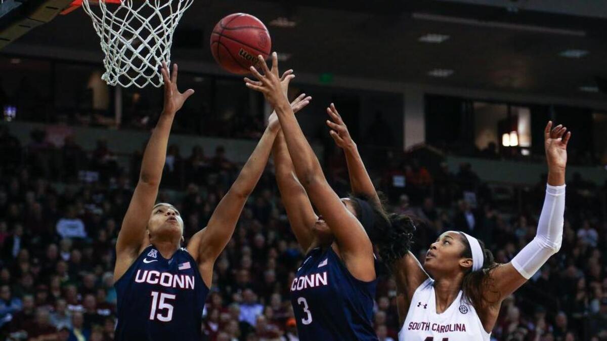 South Carolina's Alaina Coates (41) tries for a rebound as Connecticut's Gabby Williams (15) and Connecticut's Morgan Tuck (3) snag the ball during the second half of action in the Colonial Life Arena. UConn won 66-54.