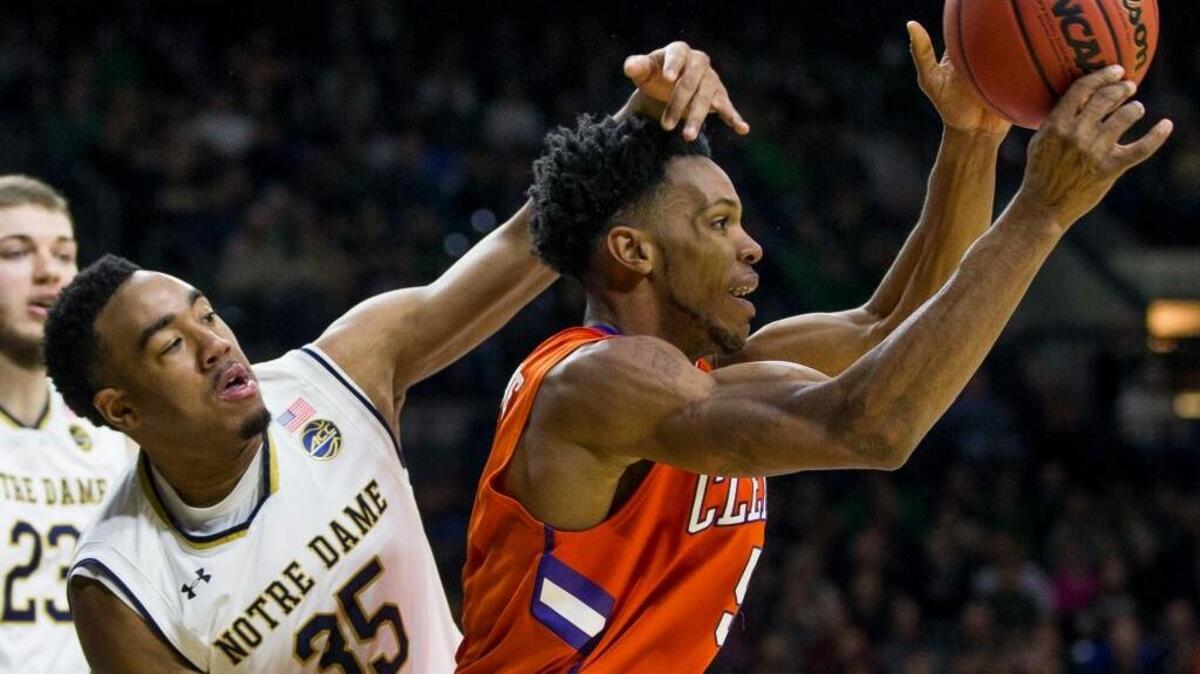 Clemson’s Jaron Blossomgame grabs a rebound in front of Notre Dame’s Bonzie Colson during the second half of Saturday. Notre Dame won 75-70.