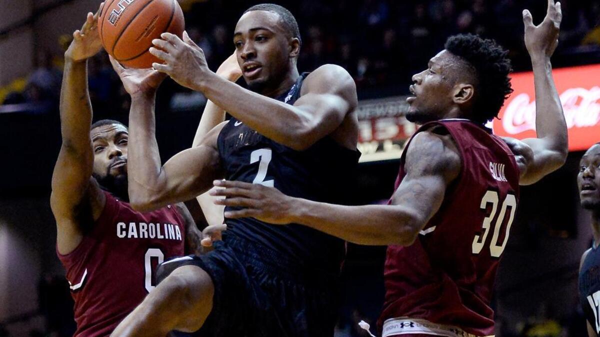 Vanderbilt’s Joe Toye passes the ball between South Carolina’s Sindarius Thornwell and center Chris Silva.