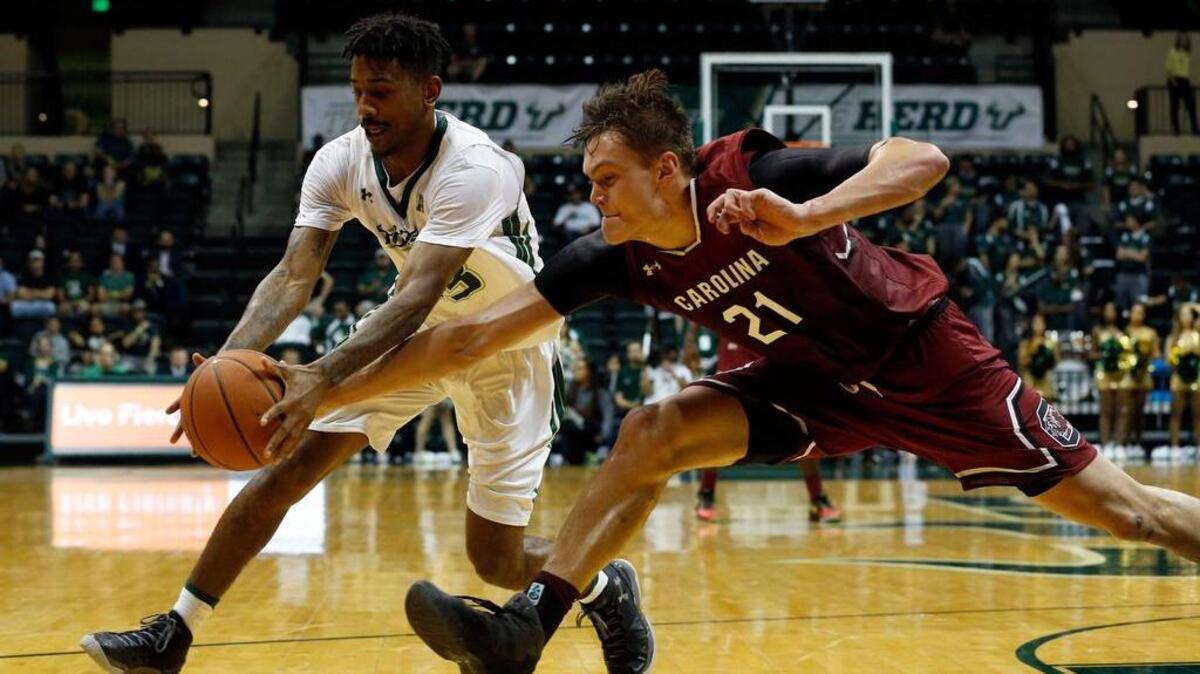 South Florida guard Geno Thorpe and South Carolina forward Maik Kotsar go after a loose ball.