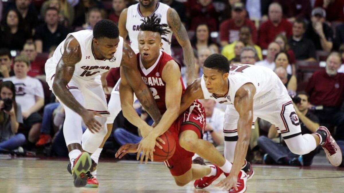 South Carolina guards Duane Notice and P.J. Dozier dive for a ball with Alabama’s Dazon Ingram.