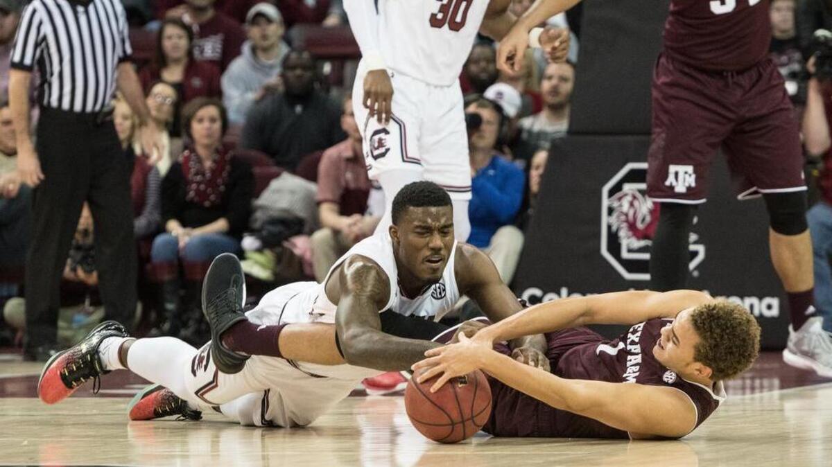 South Carolina’s Duane Notice (10) and Texas A&M's DJ Hogg (1)scramble for control of a loose ball Saturday at Colonial Life Arena.