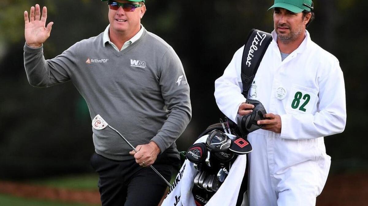 Charley Hoffman acknowledges the applause of the gallery as he and his caddie, Brett Waldman, arrive at the 18th green Thursday during the first round of the 81st Masters Tournament at Augusta National Golf Club.