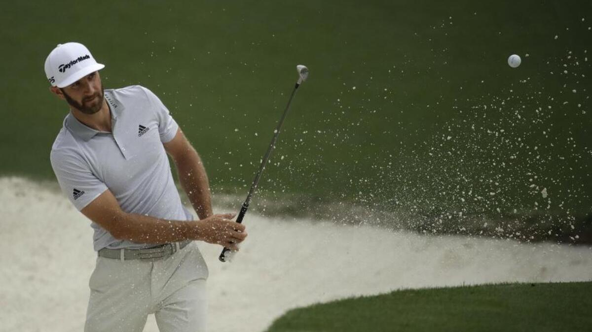 Dustin Johnson hits from a bunker on the 10th hole during a practice round for the Masters Tournament on Wednesday morning, prior to his spill down a staircase at his rental home that has his participation in the tournament in doubt.