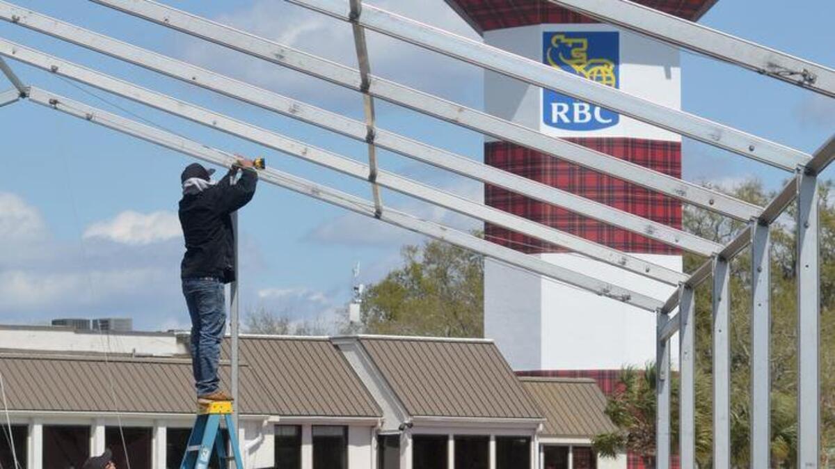 The red and plaid Harbour Town Lighthouse rises in the background as workers put up a hospitality tent next to the 18th green of Harbour Town Golf Links, as preparations for the RBC Heritage were well underway on March 21.