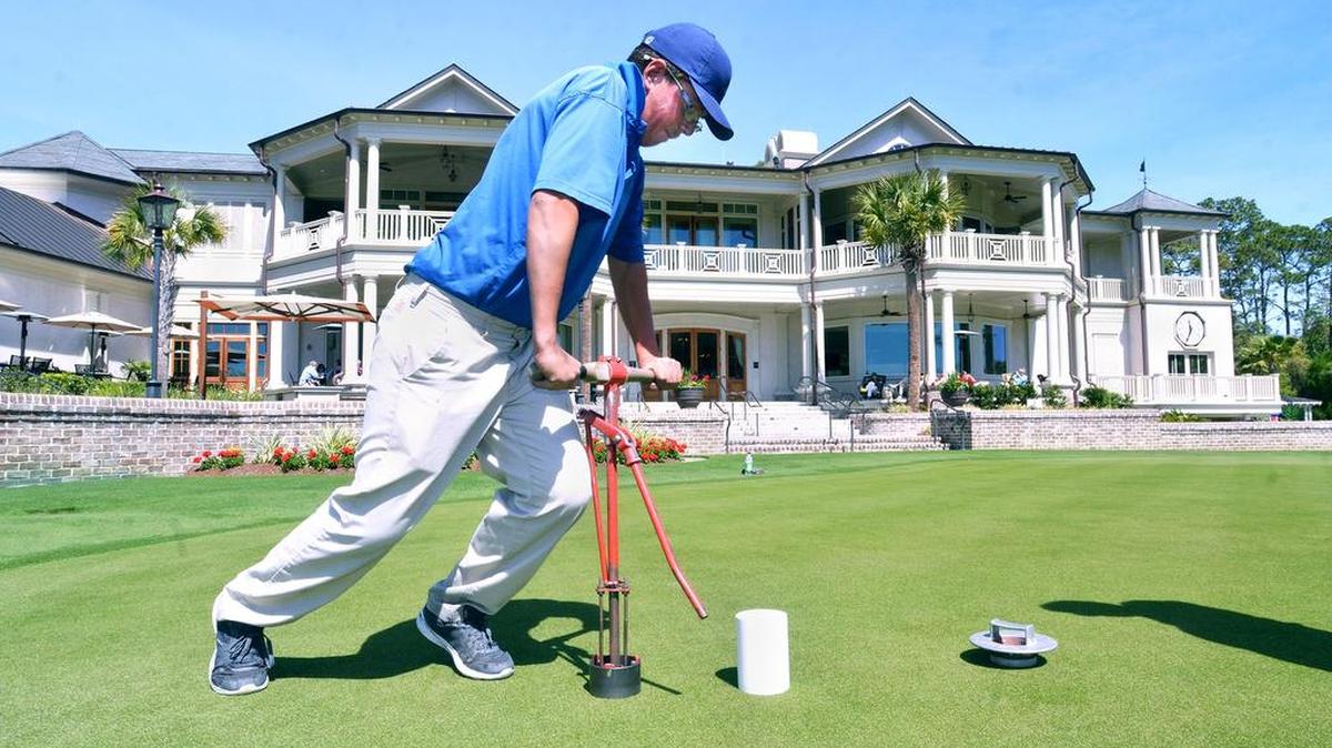 Grounds crew member Darren Smith cuts in a new hole on the putting green at Harbour Town Golf Links on April 9, 2017 as final preparations for the RBC Heritage Presented by Boeing golf tournament are made. Smith, from Scotland, “the birthplace of golf,” as he said, is an international intern at Harbour Town. Tournament director Steve Wilmot said that everything will be ready for the 49th edition of the tournament, which kicks off Monday with the traditional cannon blast.