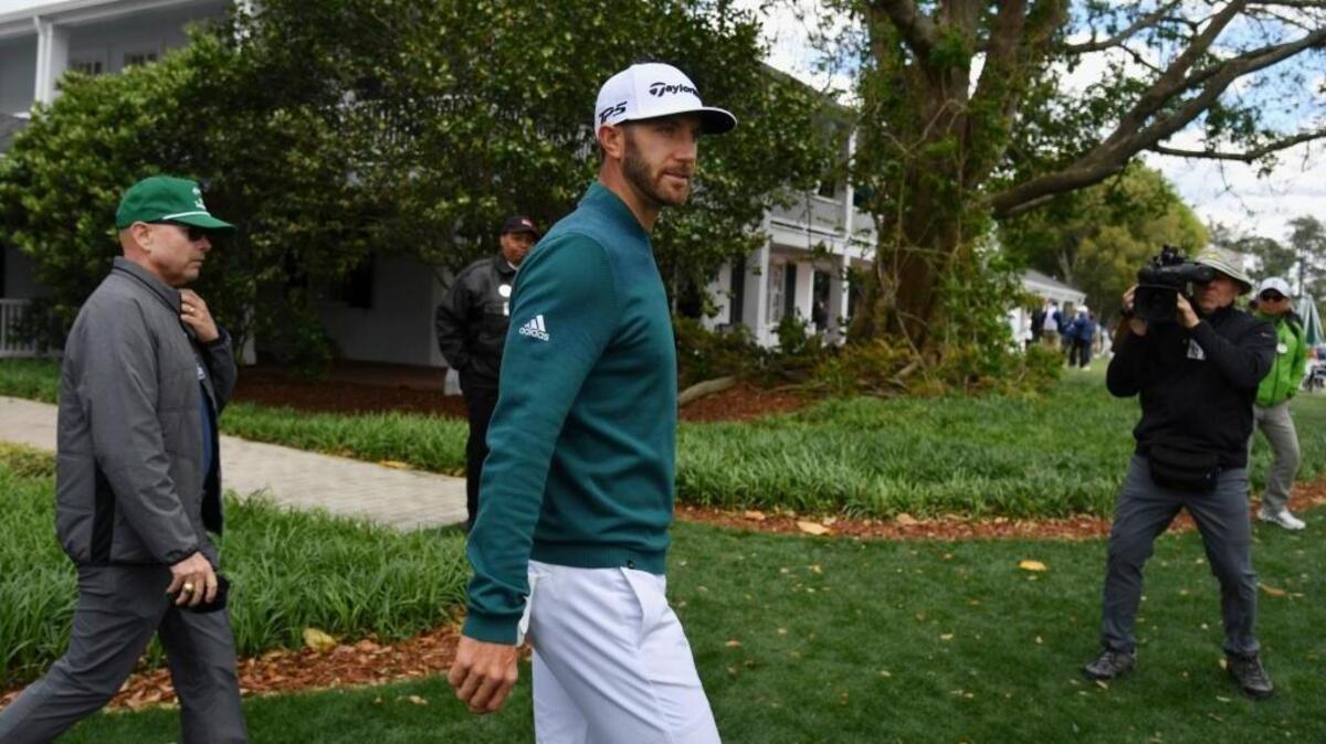 Dustin Johnson walks off the first tee after deciding not to play in the opening round of the Masters.