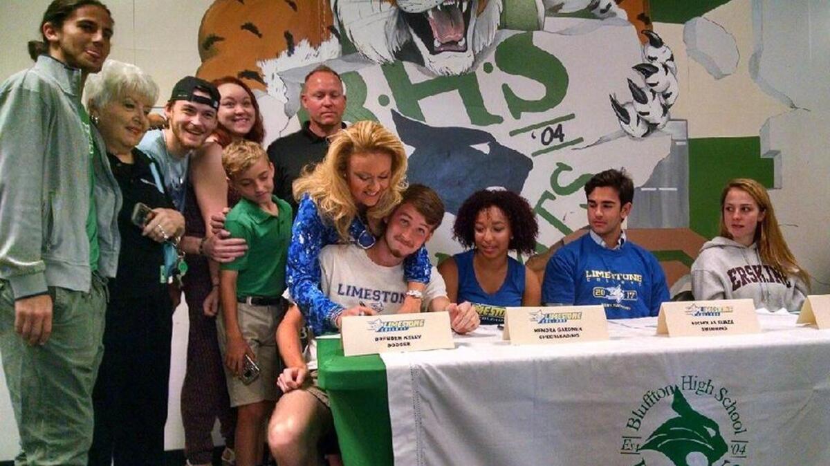 Bluffton’s Brenden Kelly gets some parental help in finalizing his national letter-of-intent to play soccer next year at Limestone College. Looking on were fellow Bobcats and Limestone signees Kendra Gardner (cheerleading) and Nicholas Suaza (swimming), along with Erskine’s Annie Franklin (volleyball).