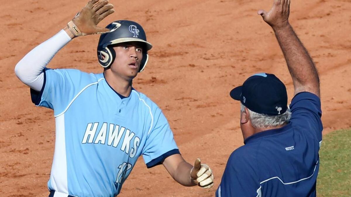 Hilton Head’s Eric Foggo high fives Seahawks head coach Ken Spoucy as he rounds third base after hitting a three-run homer in the third inning of the Class 4A District VII baseball championship game versus Chapin on May 2, 2017.
