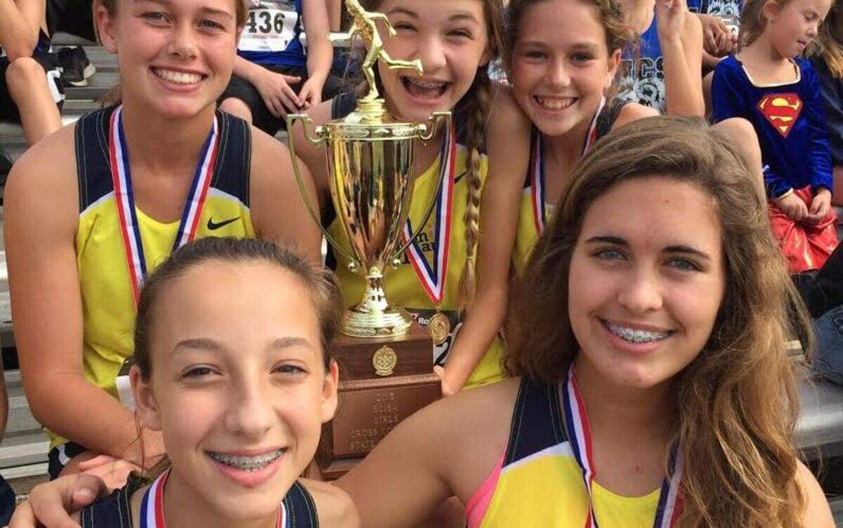 The  John Paul II girls cross country team celebrates its SCISAA Class 1-A cross country title on Saturday at Heathwood Hall in Columbia.