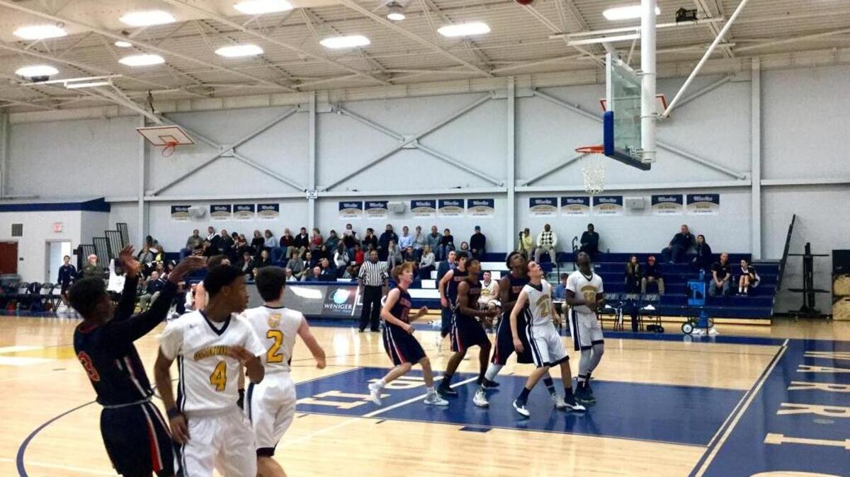 Hilton Head Prep’s Iam Plummer, left, watches as a 3-pointer drops through the basket in the Dolphins’ win at John Paul II on Tuesday night.